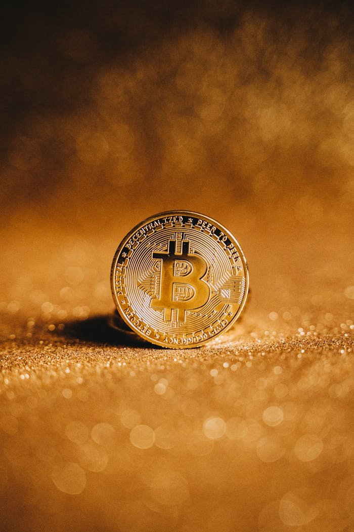 Close-up of a golden Bitcoin with a sparkling background, symbolizing digital finance.